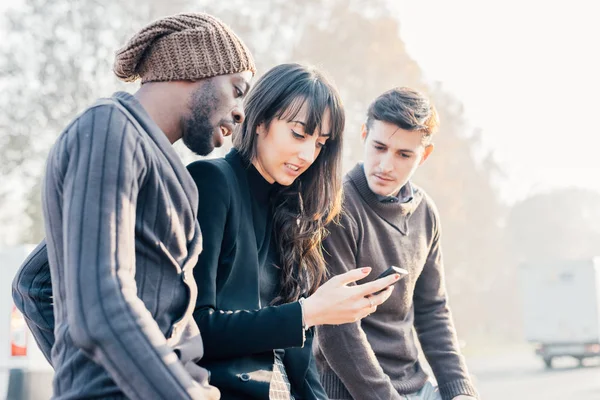 Multietniskt vänner håller smartphone — Stockfoto