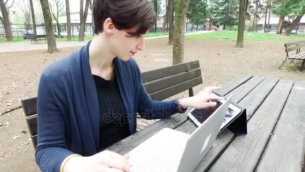 Vrouw in park met behulp van computer — Stockvideo