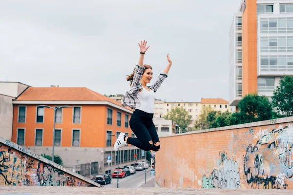 Женщина прыгает на открытом воздухе в городе — стоковое фото