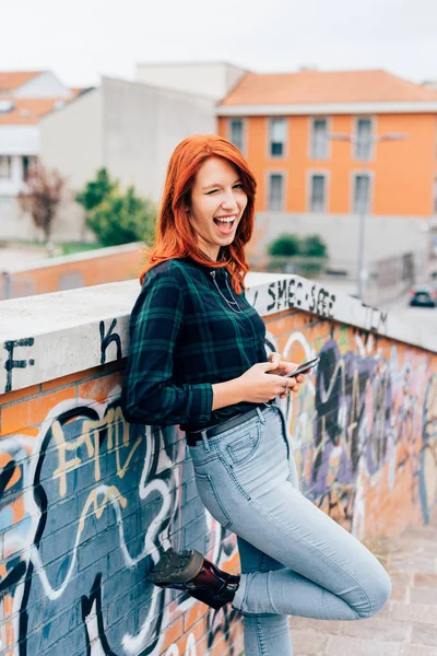 Rossa donna appoggiata al muro di mattoni — Foto Stock