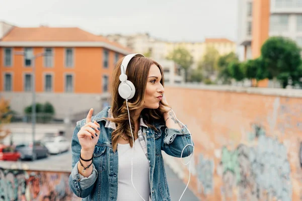 Kvinna lyssna musik med hörlurar — Stockfoto