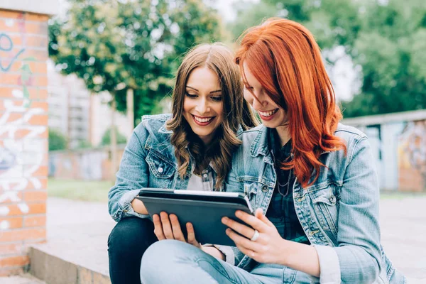 Ženy sedí na schodiště pomocí tabletu — Stock fotografie