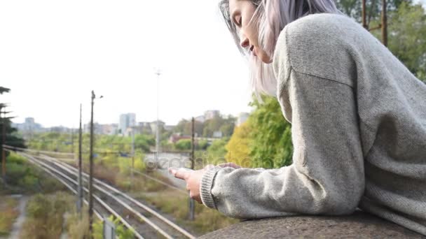 Woman leaning on handrail using smartphone — Stock Video