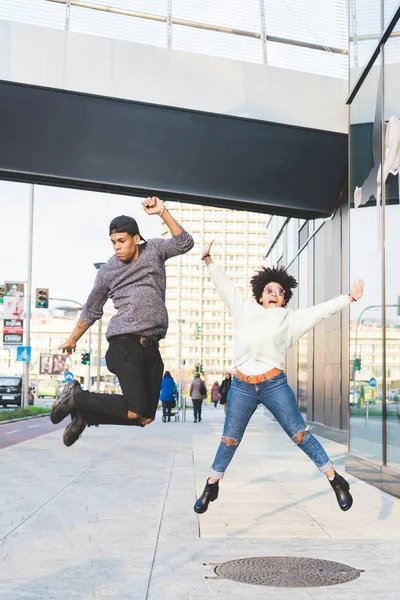 Couple multiethnique sautant en ville — Photo