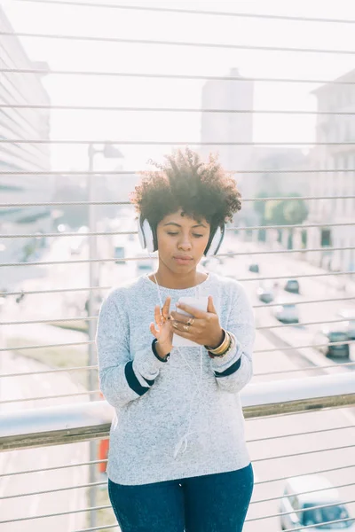 Afro donna ascoltare musica con le cuffie — Foto Stock