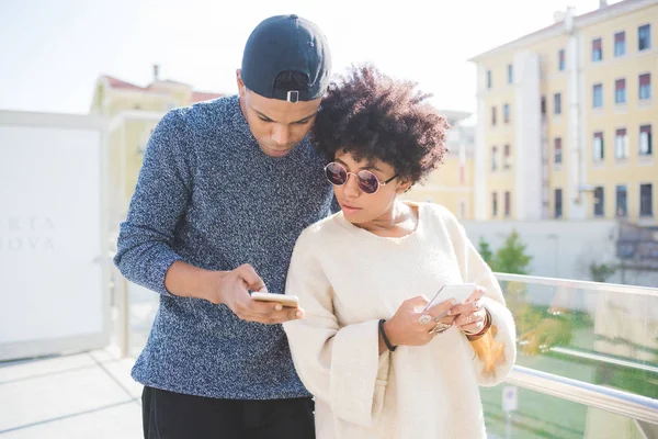 Multiethnic couple using smartphone — Stock Photo, Image