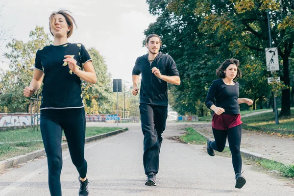 Mujeres y hombre corredores corriendo al aire libre — Foto de Stock