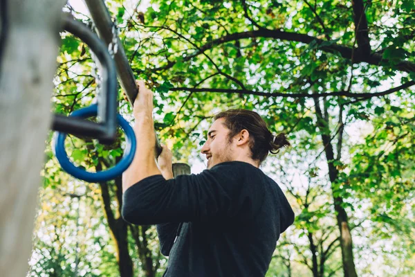 Człowiek, szkolenia w parku za pomocą pierścieni — Zdjęcie stockowe