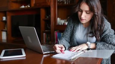 Genç, güzel, doğu doğulu bir kadın masa başında oturmuş müzik yazıyor. Çalışıyor, konsept yapıyor.