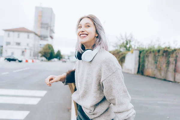 Donna in città a piedi ascoltando musica — Foto Stock