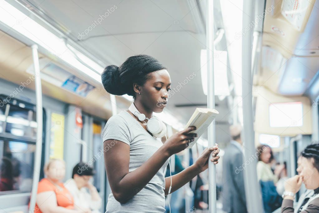 woman traveling on subway reading book