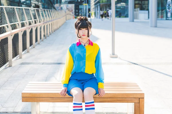 Asiatic woman on bench outdoor in city — Stock Photo, Image