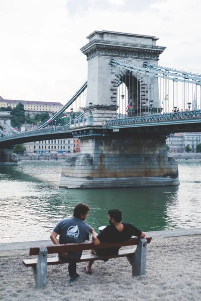 Konuşan bir tezgah üzerinde oturan iki kişi 