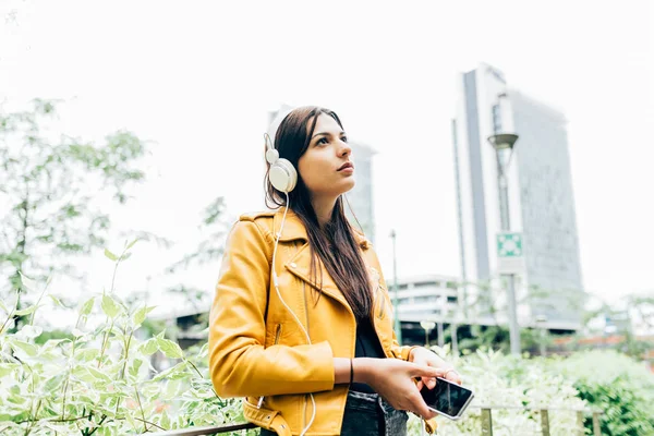 Žena poslouchající hudbu se sluchátky — Stock fotografie