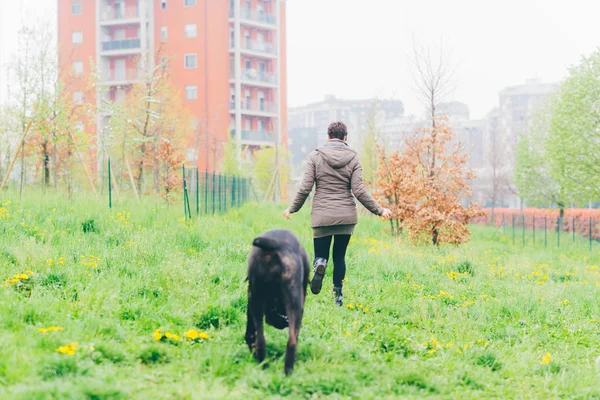 Kvinna som spelar i parken med hund — Stockfoto