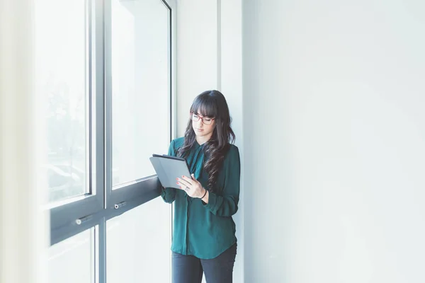 Mujer de negocios cerca de ventana celebración tableta —  Fotos de Stock