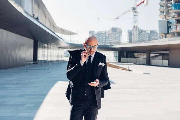 Zakenman buiten in stad met smartphone — Stockfoto