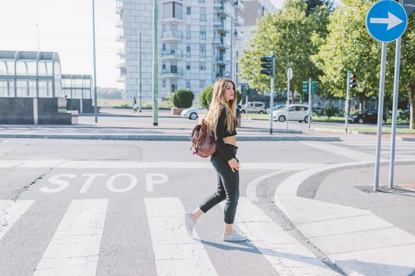 Woman wearing backpack crossing pedestrian — Stock Photo, Image