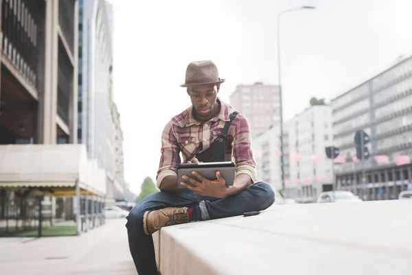 Человек в городе сидит с помощью планшета — стоковое фото