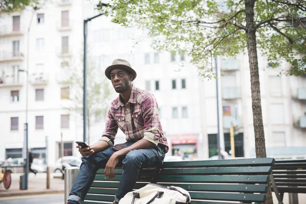 man on bench holding smartphone