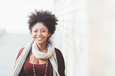 Kadın kameraya bakıp gülümsüyor.