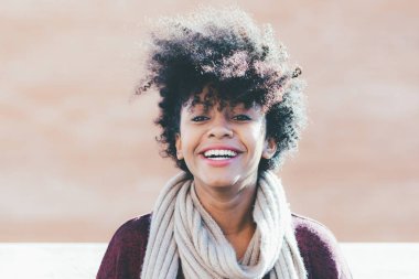 Kadın kameraya bakıp gülümsüyor.