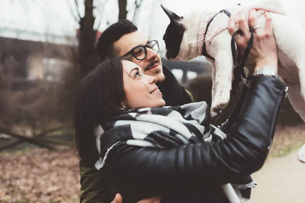 Casal segurando cachorro bulldog francês — Fotografia de Stock