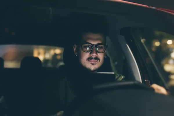 Homem usando smartphone no carro à noite — Fotografia de Stock