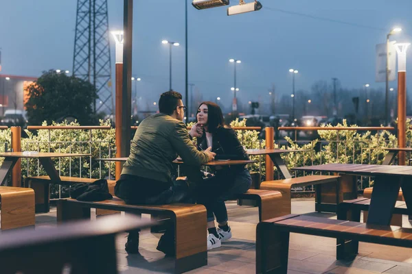 Paret sitter utomhus i natt talar — Stockfoto