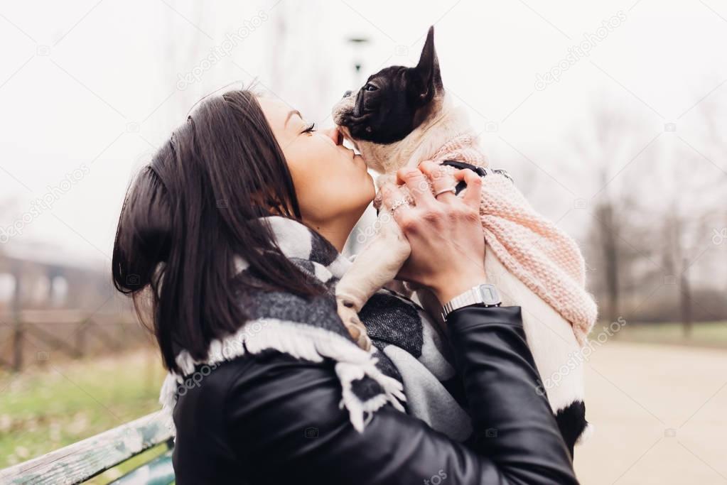 woman hugging french bulldog puppy 