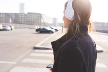 Kadın akıllı telefon ve kulaklık ile müzik dinleme 
