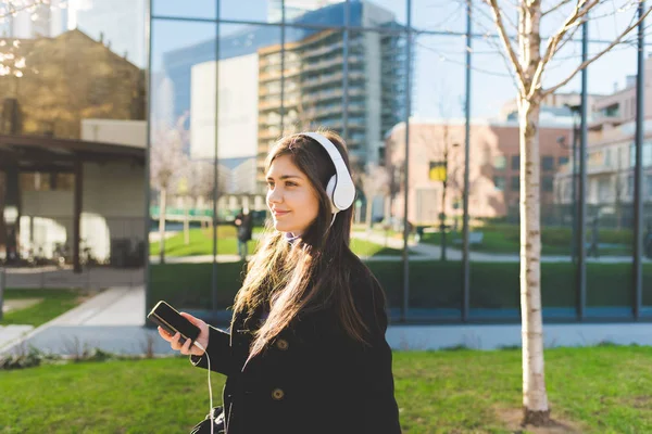 Kadın akıllı telefon ve kulaklık ile müzik dinleme — Stok fotoğraf