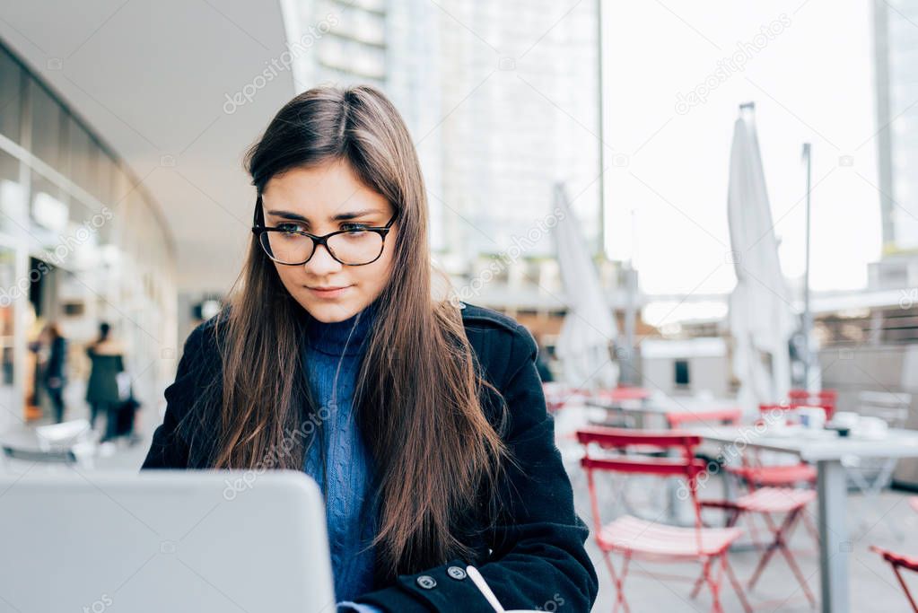 woman in city sitting bar using computer 