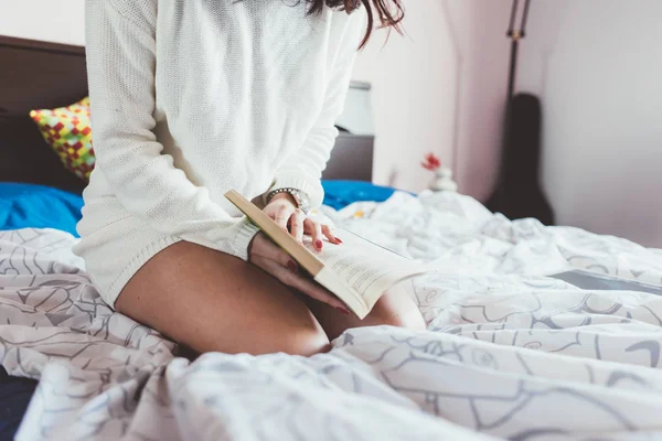 Kadın yatakta kitap okuyor. — Stok fotoğraf