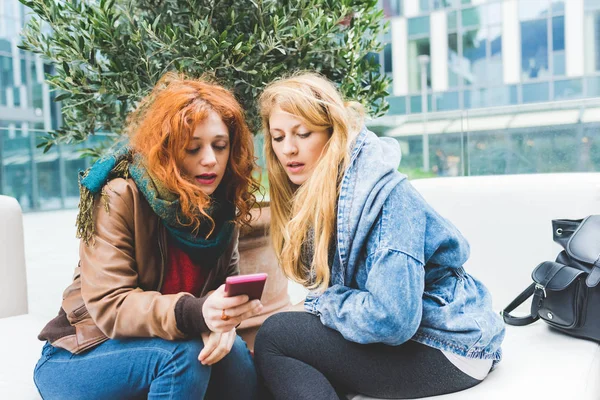 Kvinnor som använder smartphone utomhuspool — Stockfoto