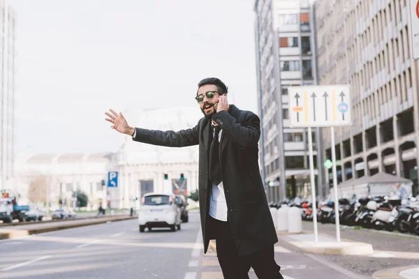 Hombre de negocios pidiendo taxi hablando en el teléfono inteligente —  Fotos de Stock