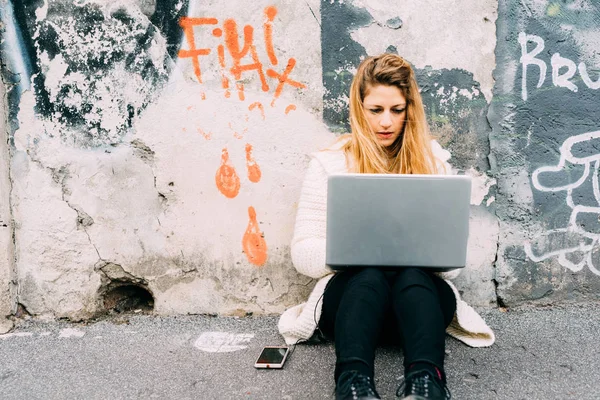 Mulher usando computador sentado ao ar livre — Fotografia de Stock