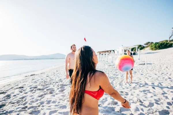 Друзі грають волейбол з пляжним м'ячем — стокове фото