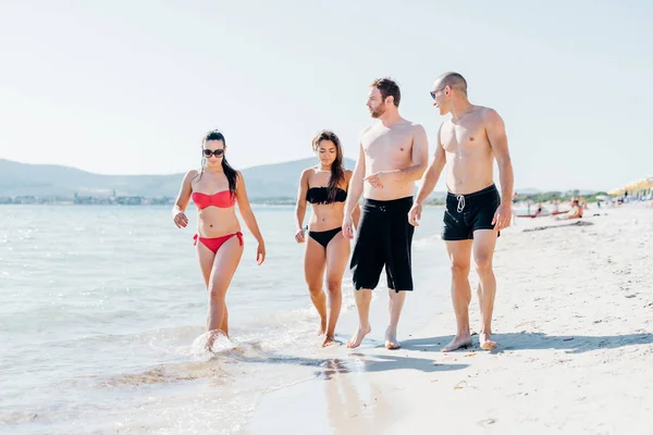 Amici che camminano sulla spiaggia divertendosi — Foto Stock