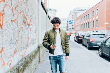 Smartphone kullanarak şehirde yürüyen adam