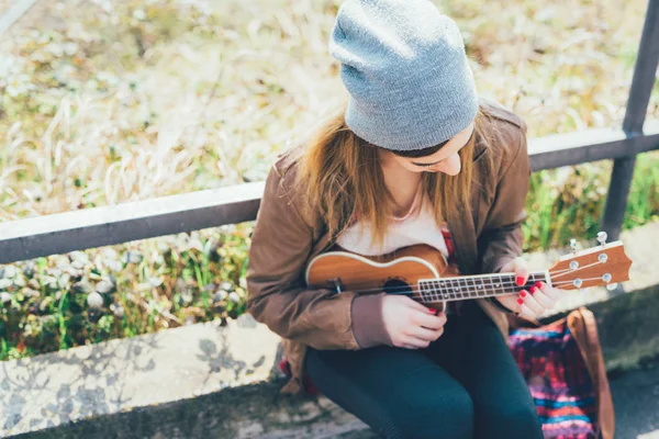 Vrouw in stad ukulele spelen — Stockfoto