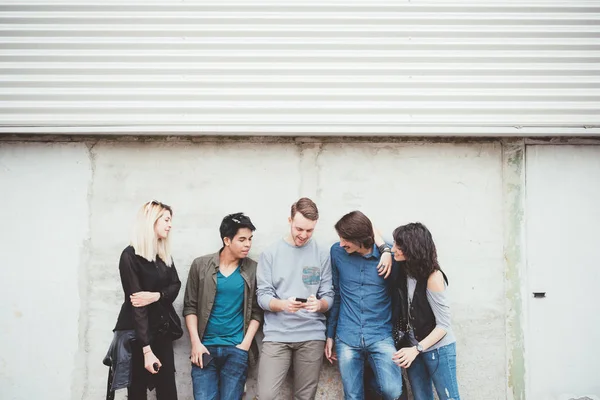 Friends leaning against a wall — Stock Photo, Image
