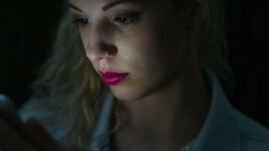 Gece akıllı telefon kullanan bir kadın.