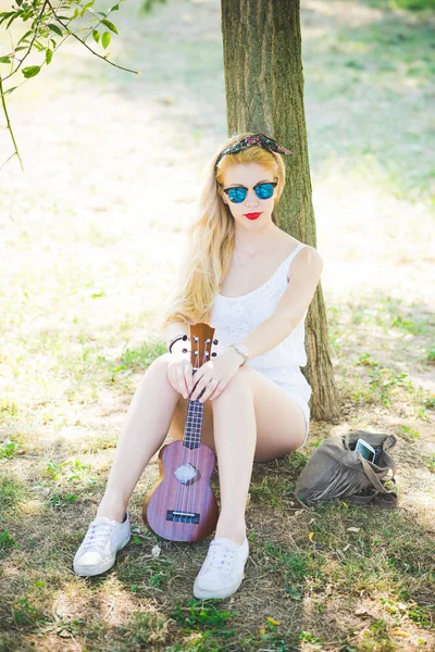 Mulher ao ar livre no parque da cidade jogando ukulele — Fotografia de Stock