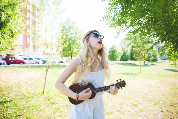 Woman outdoor city park playing ukulele — Stock Photo, Image