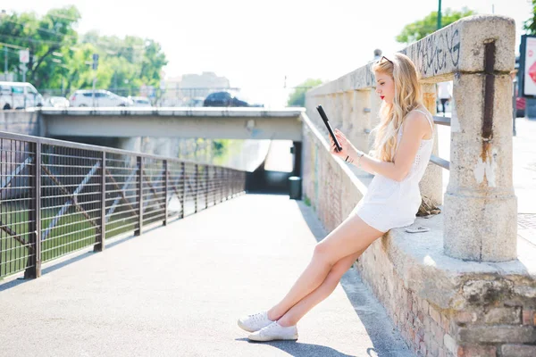 Donna in città luce posteriore utilizzando tablet — Foto Stock