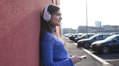 Güzel genç bir kadın müzik dinliyor kulaklıkları ve akıllı telefonları var. Her şeyden uzaklaşıyorlar. Rahatlatıcı, özgürlük kavramı.