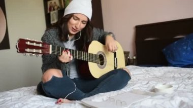 Gitar çalan genç, güzel bir kadın. Müzisyen, besteci, küçük işletme konsepti. 