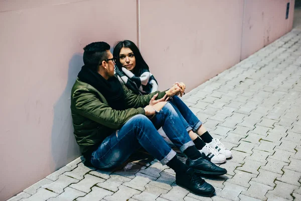 Pareja sentado al aire libre en el suelo charlando —  Fotos de Stock