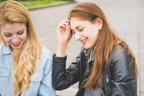 Flickor chattar och använda tekniska enheter — Stockfoto